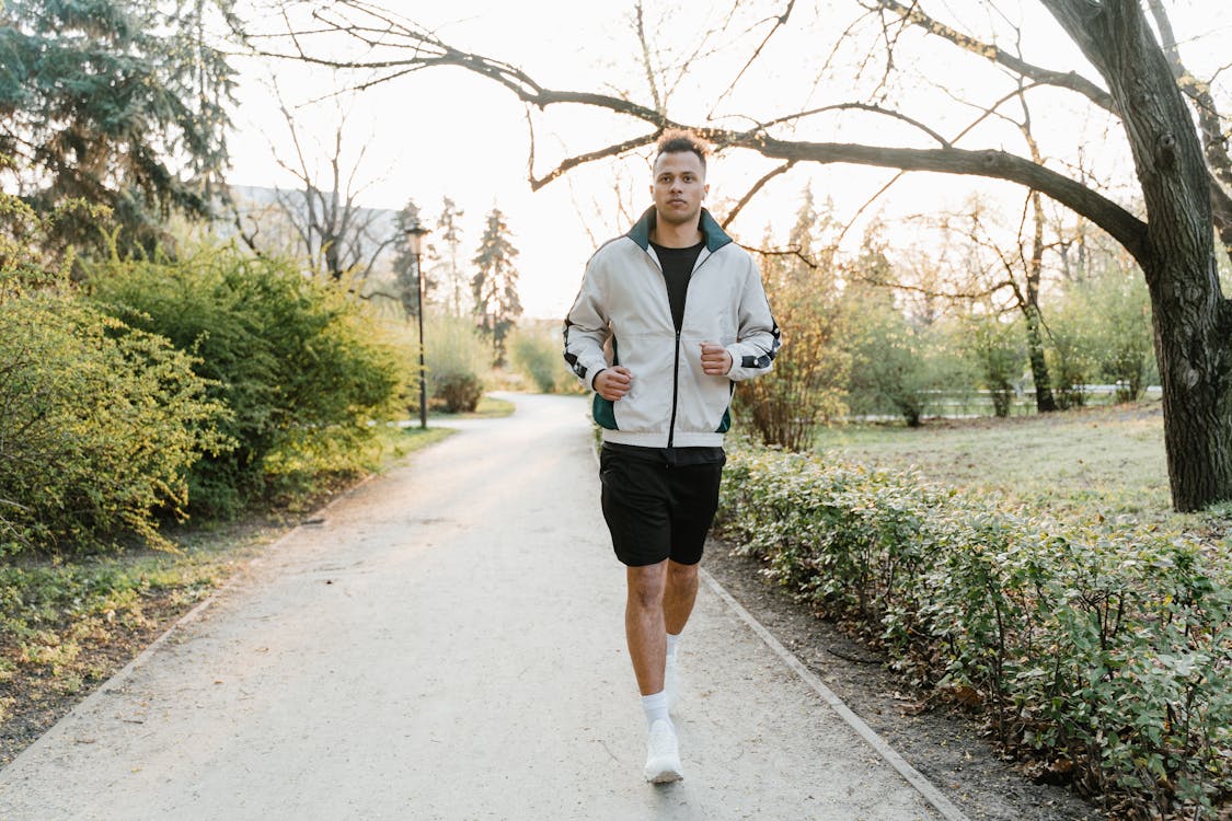 Hombre corriendo en un parque combinando trabajo y deporte — compaginar deporte y vida cotidiana