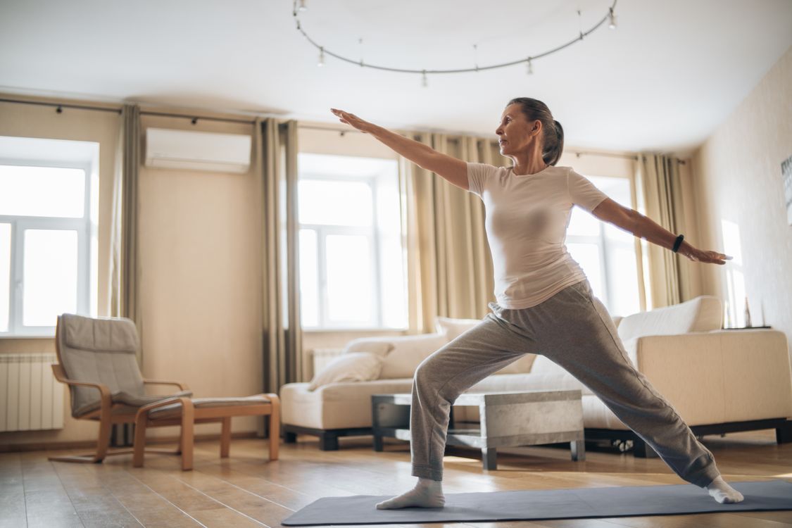 Mujer mayor practicando yoga y ejercicio durante la menopausia — actividad física y bienestar
